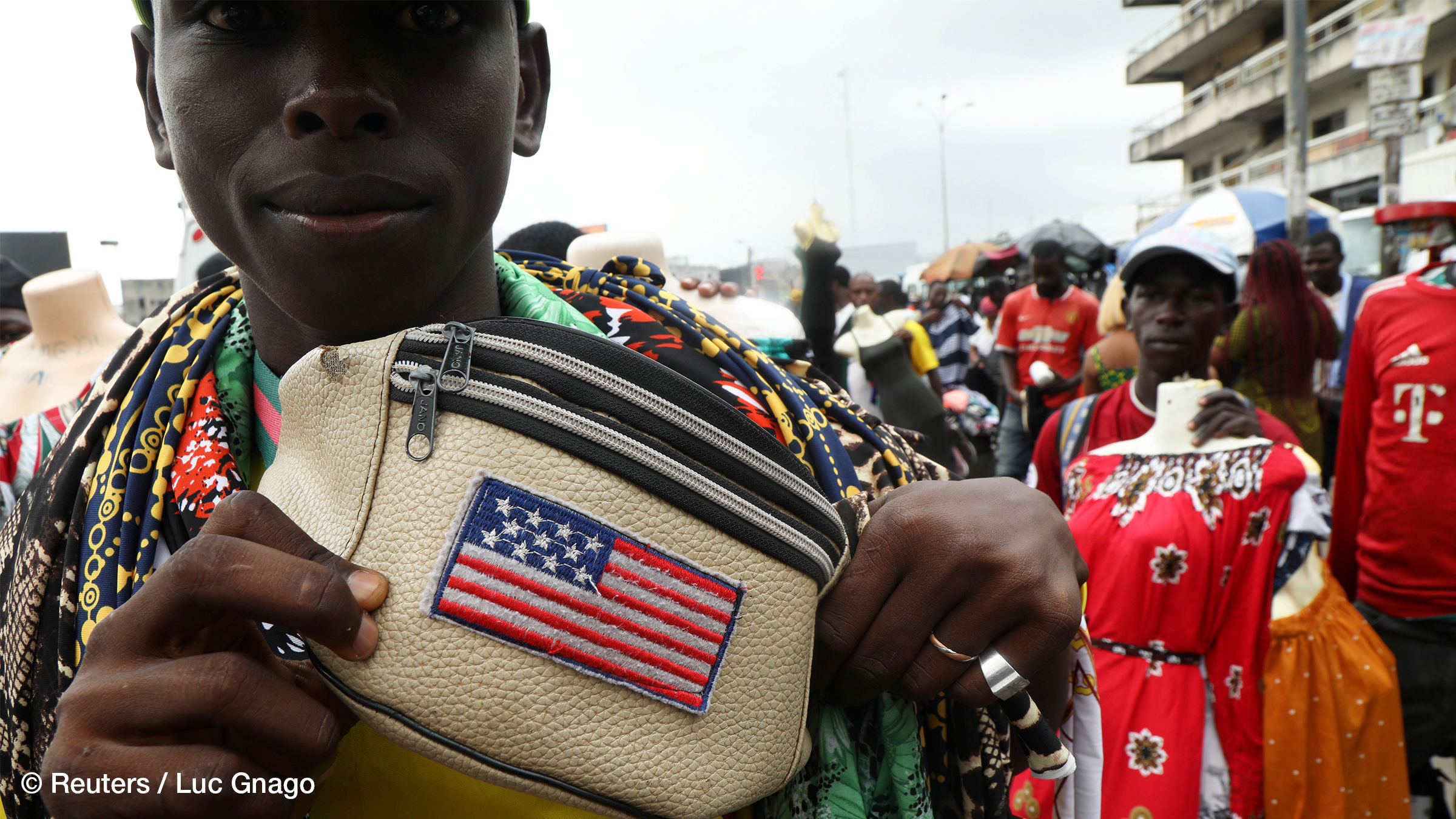 Ein Straßenverkäufer zeigt die auf seine Tasche gedruckte US-Flagge auf einer Straße in Abidjan, Elfenbeinküste