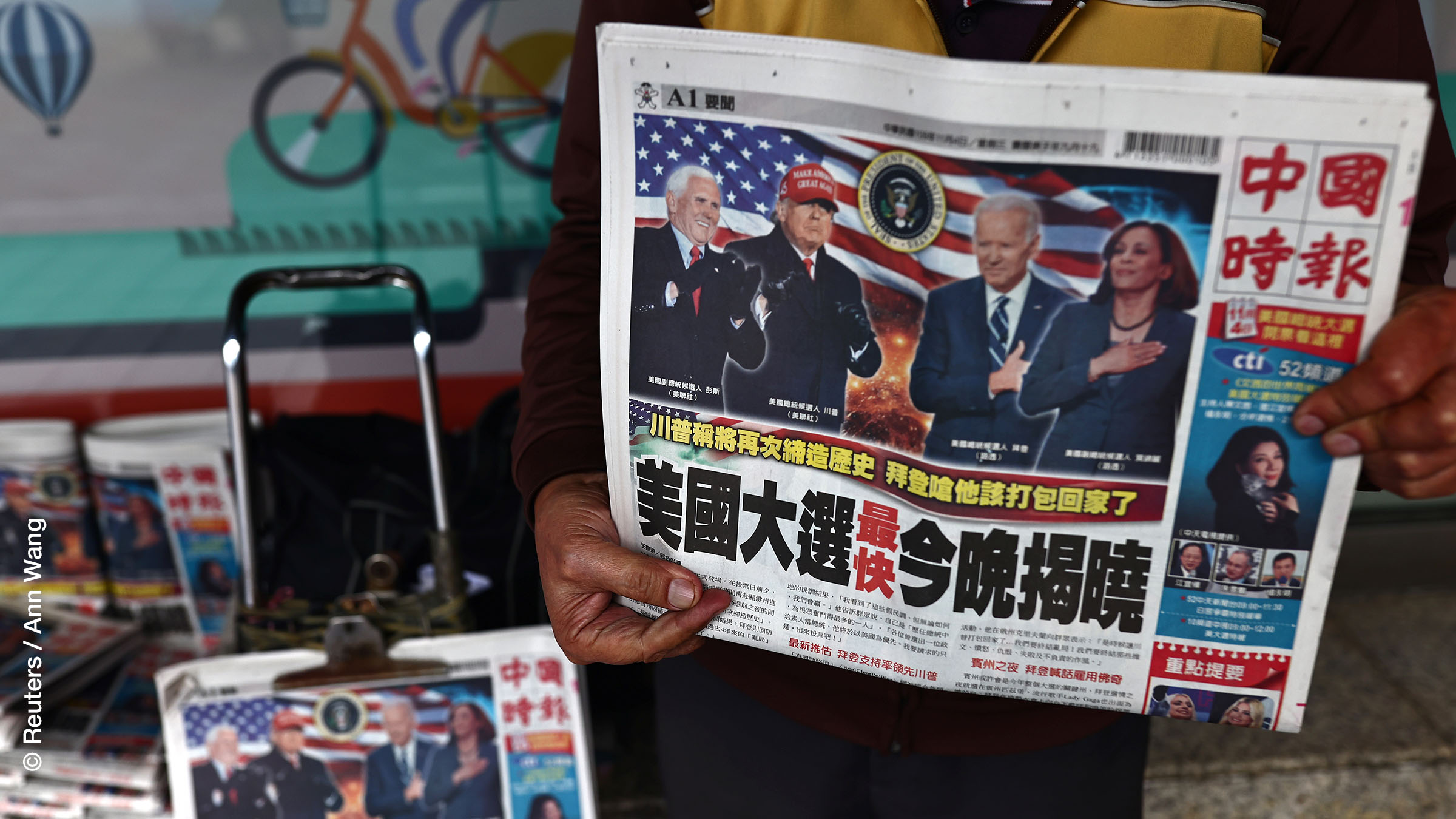A man sells newspapers with front page articles about the U.S. election along a street in Taipei, Taiwan.